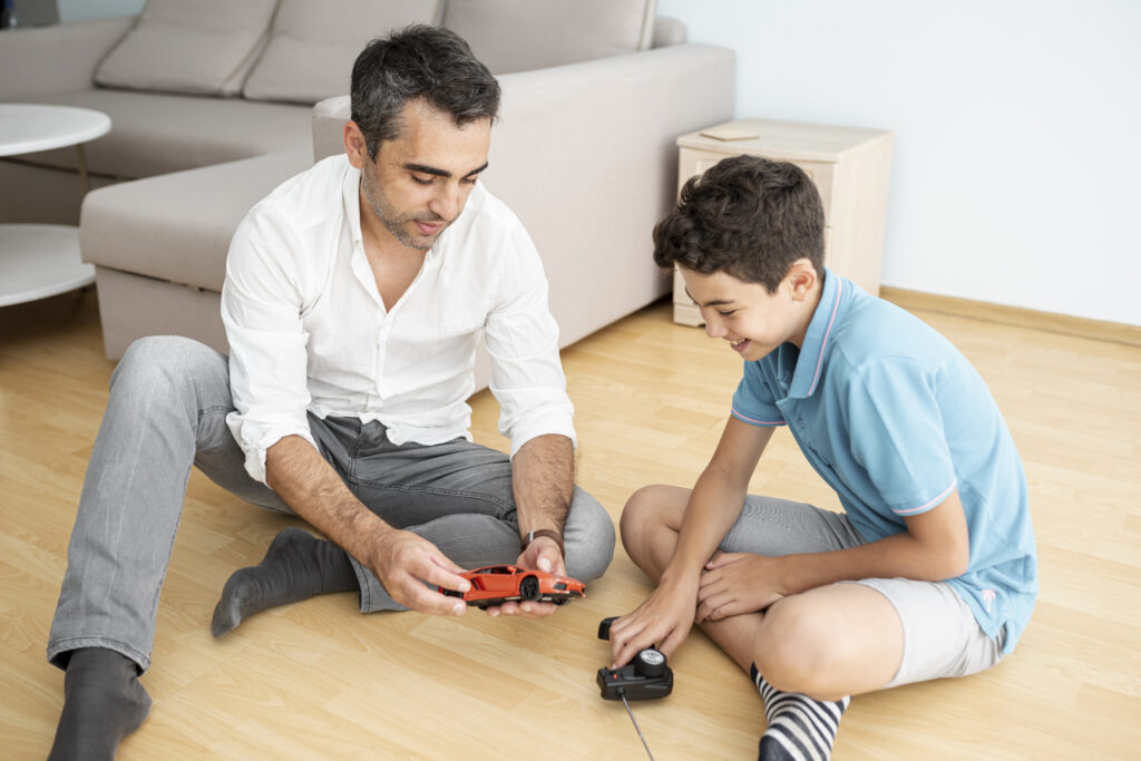 father and kid playing with remote control toys