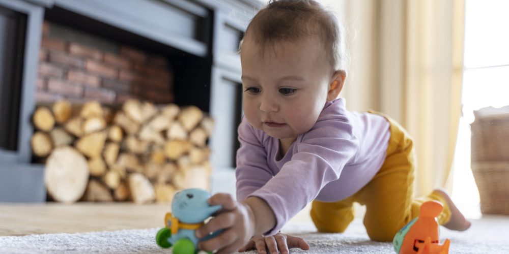 adorable-baby-playing-with-toy-home-floor