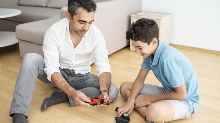 father and kid playing with remote control toys